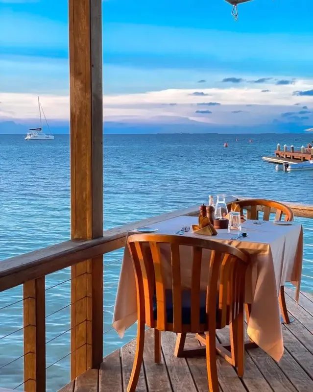 Table dressée sur une terrasse en bois face à la mer
