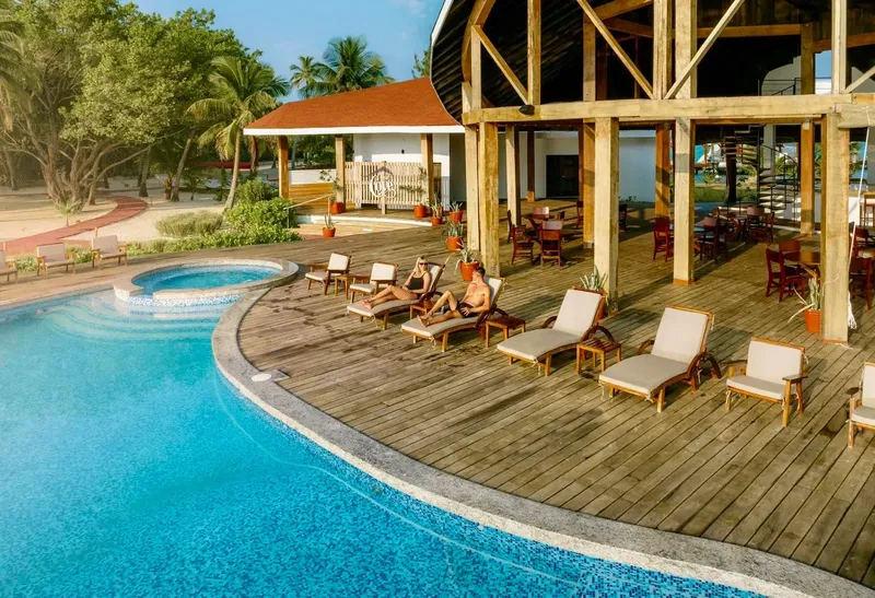 Terrasse en bois avec piscine et chaises longues ensoleillées