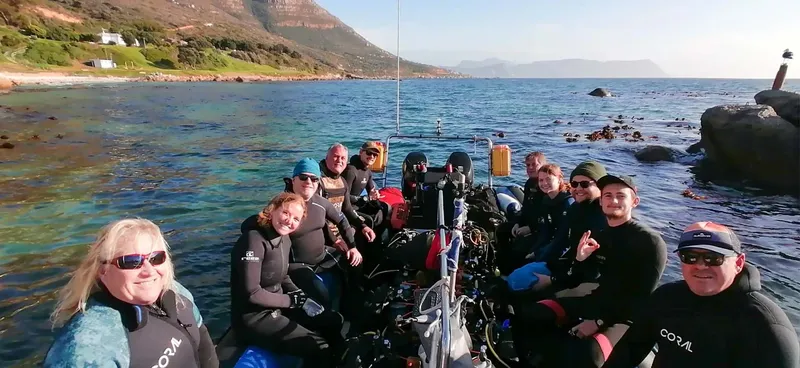 Groupe de plongeurs souriants sur un bateau semi-rigide en mer