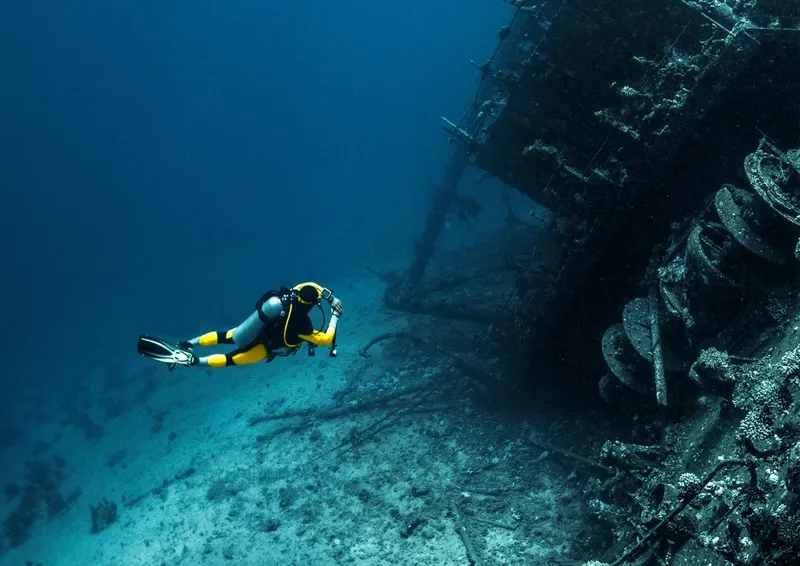 Plongeur explorant une épave sous-marine avec une visibilité claire