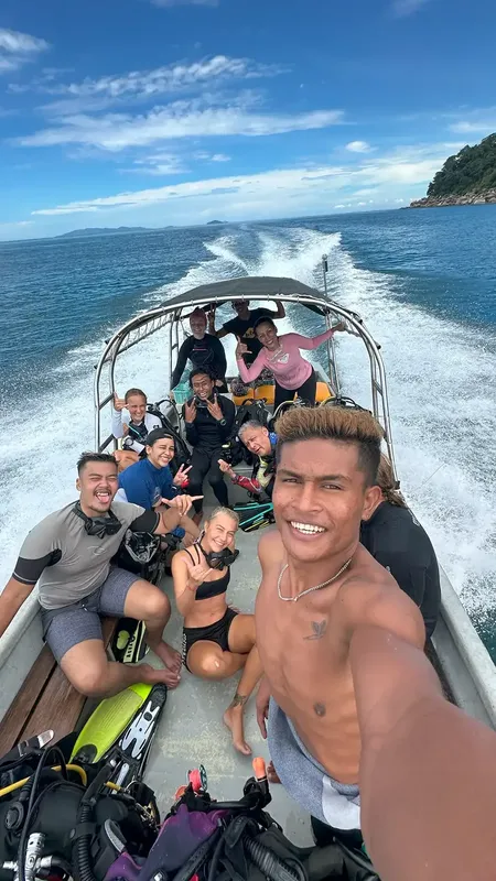 Groupe de plongeurs souriants à bord d'un bateau en mer