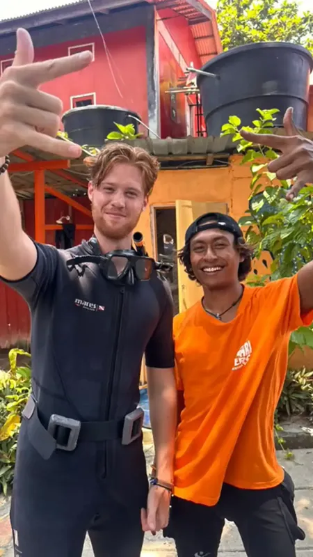 Deux personnes souriantes, un plongeur et un instructeur, posent ensemble