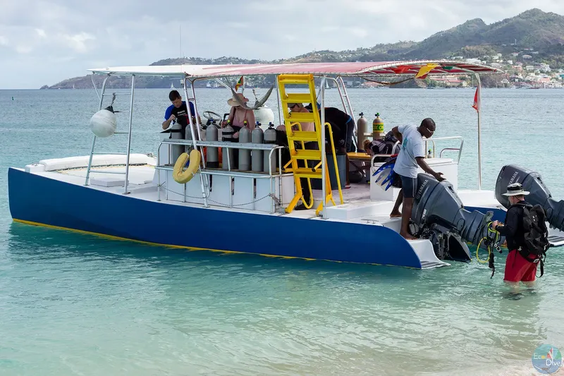 Bateau de plongée bleu avec des plongeurs et de l'équipement à bord