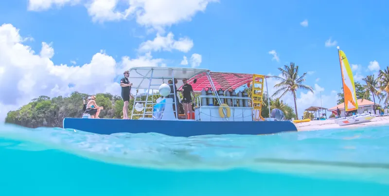 Bateau de plongée avec des personnes et des équipements près d'une plage