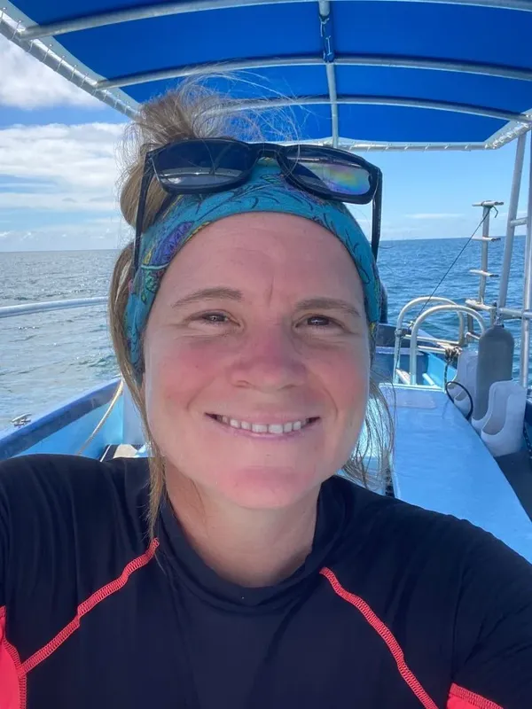 Femme souriante portant des lunettes de soleil à bord d'un bateau