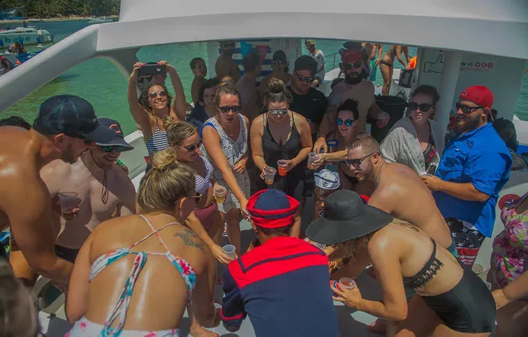 Groupe de personnes souriantes sur un bateau en mer, ambiance festive