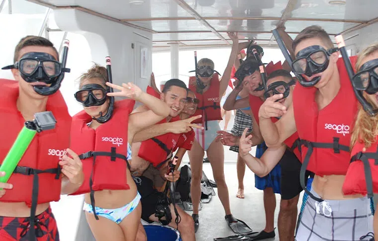 Groupe de plongeurs souriants sur un bateau avec équipement snorkeling