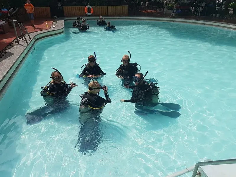 Groupe de plongeurs en formation dans une piscine bleu clair