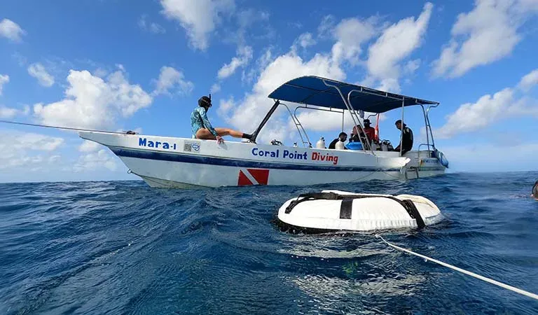 Bateau de plongée avec des passagers et une bouée en mer