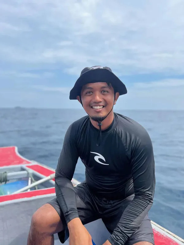 Homme souriant portant une combinaison de plongée sur un bateau en mer
