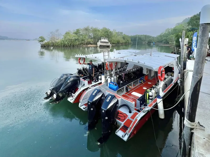 bateaux de plongée avec bouteilles à quai dans une baie