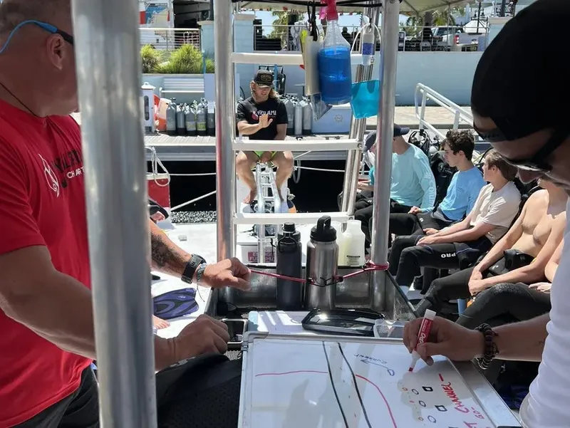 Groupe de personnes suit une formation de plongée sur un bateau