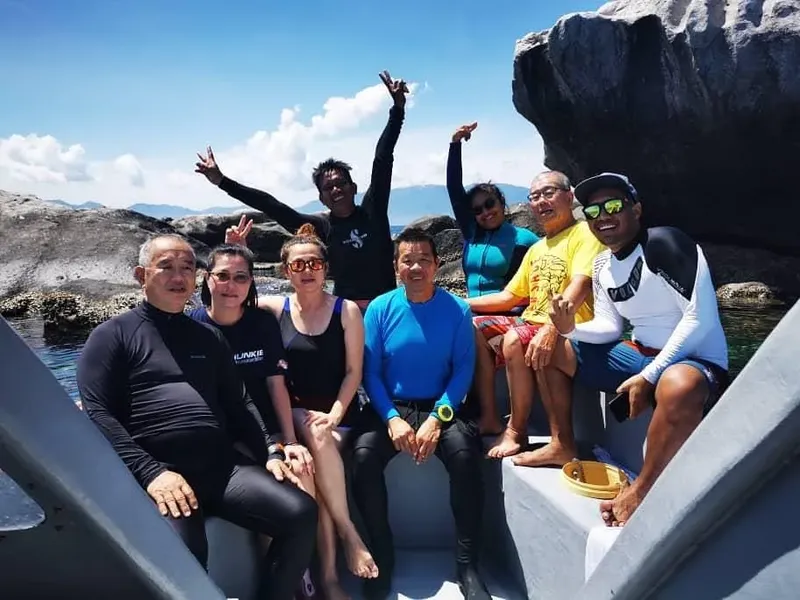 Groupe de plongeurs souriants à bord d'un bateau en mer