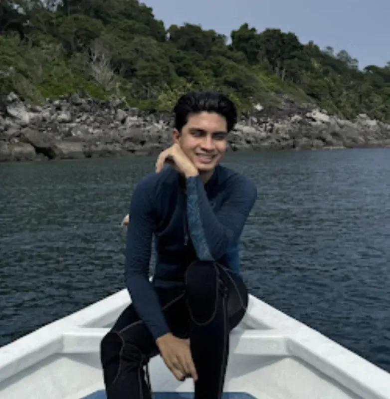Jeune homme souriant en combinaison de plongée sur un bateau