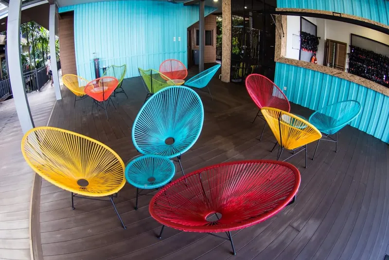 Terrasse colorée avec chaises en corde et rangée de bouteilles