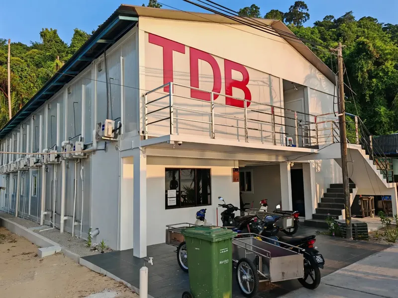 Bâtiment blanc avec les lettres TDB en rouge sur le toit