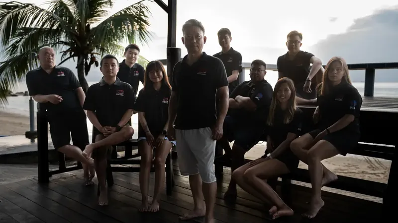 Groupe de personnes souriantes posant sur une terrasse en bois