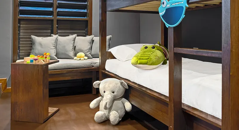 Lit superposé dans une chambre, avec des jouets et coussins