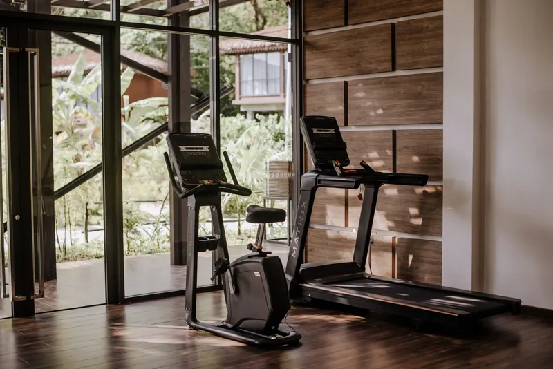 Salle de sport avec tapis de course et vélo d'appartement modernes