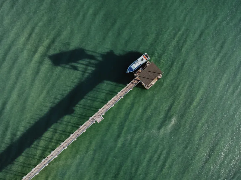Bateau amarré à un ponton en bois sur une eau turquoise
