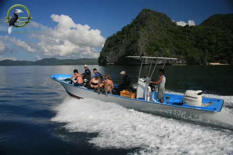 Groupe de plongeurs à bord d'un bateau bleu en pleine navigation