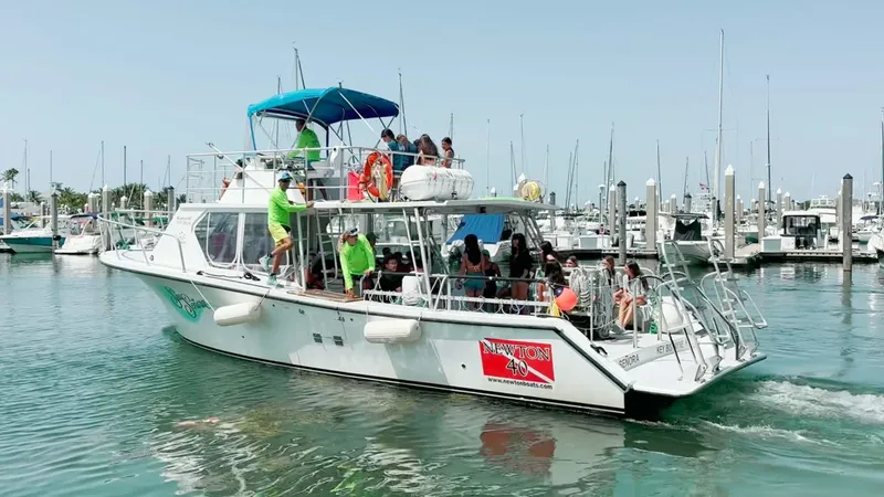 Bateau de plaisance rempli de personnes naviguant dans un port ensoleillé