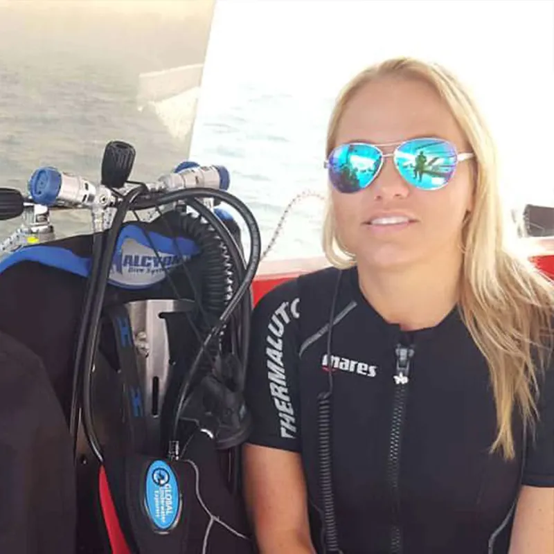 Plongeuse souriante avec combinaison et équipement sur un bateau
