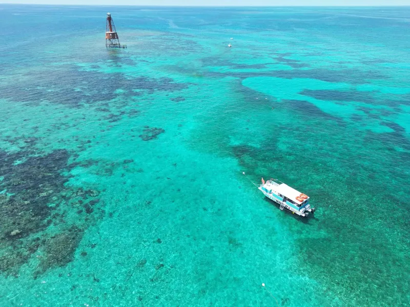 Vue aérienne d'un bateau de plongée sur une eau turquoise et claire