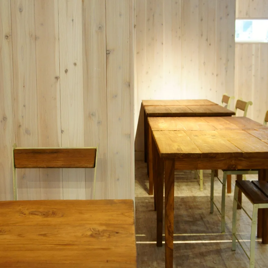 Tables et chaises en bois dans une salle lumineuse et claire