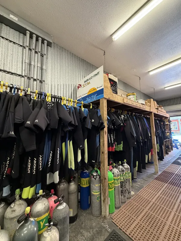 intérieur d'un centre de plongée avec combinaisons suspendues et bouteilles