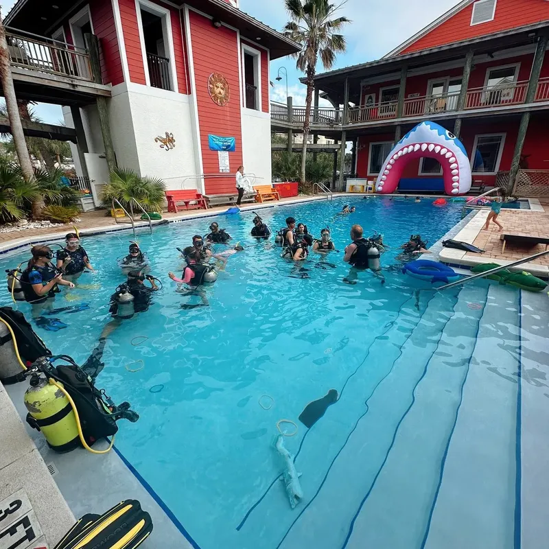 Groupe de plongeurs en formation dans une piscine avec équipement