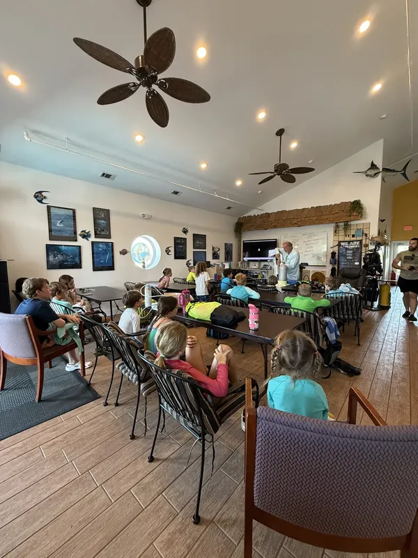 Groupe d'enfants et d'adultes en cours dans une salle lumineuse