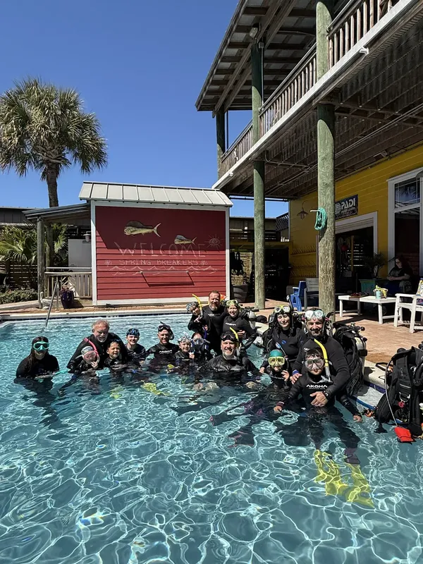 groupe de plongeurs équipés dans une piscine devant un centre