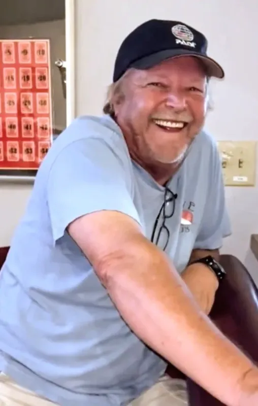 Homme souriant portant une casquette et des lunettes sur le nez