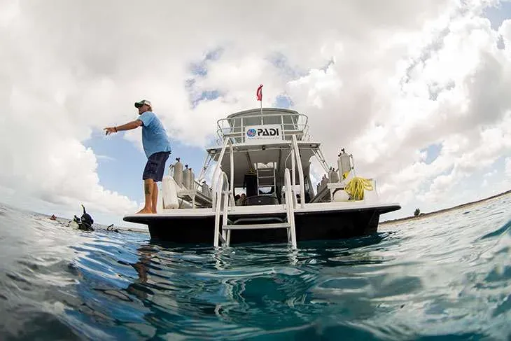 Bateau de plongée avec un instructeur et des bouteilles à bord