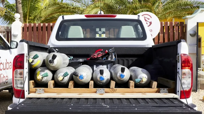 Bouteilles de plongée chargées dans la benne d'un pick-up blanc