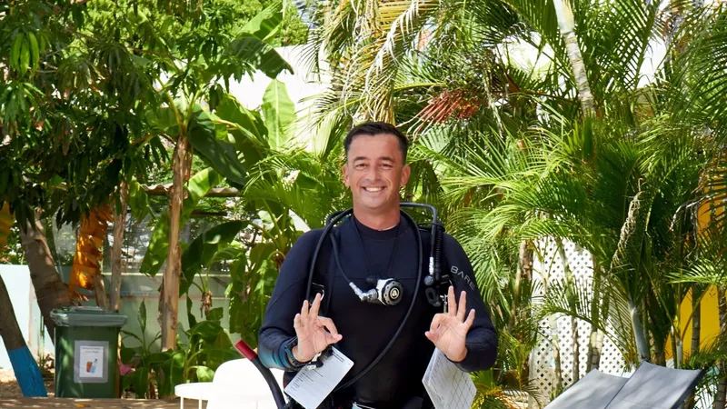 Plongeur souriant en combinaison avec son équipement de plongée complet