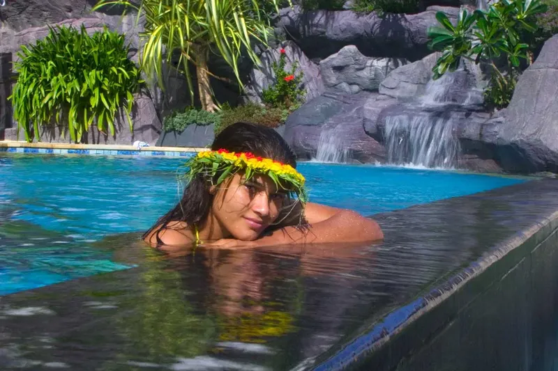 Jeune femme avec une couronne de fleurs dans l'eau turquoise
