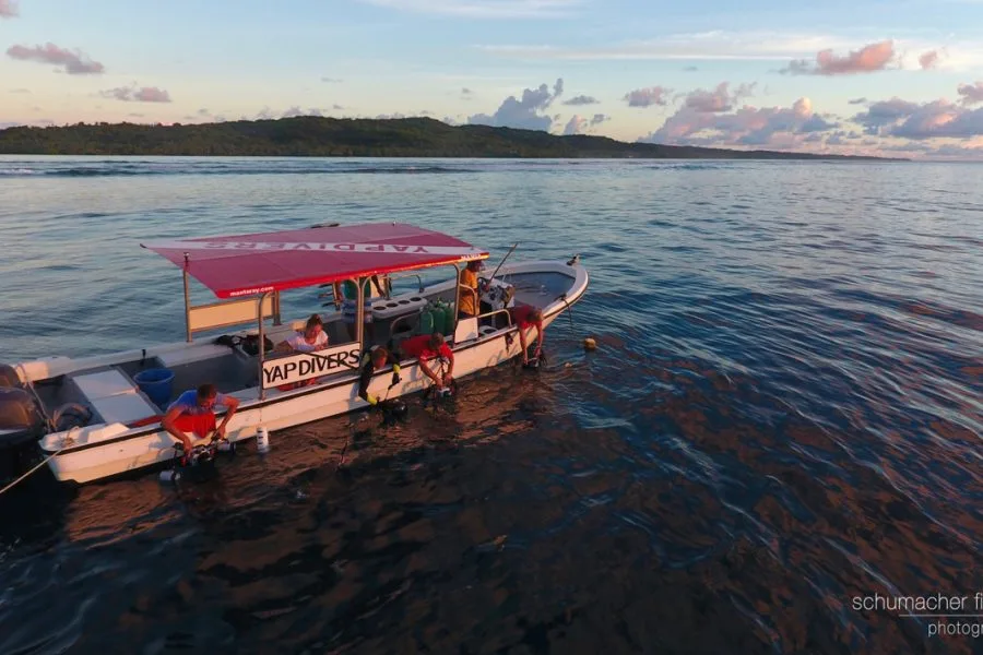 Bateau de plongée avec des plongeurs préparant leur matériel en mer