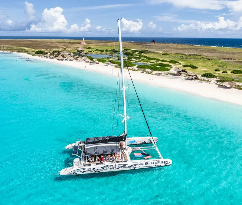 Catamaran amarré dans une eau turquoise peu profonde avec des passagers