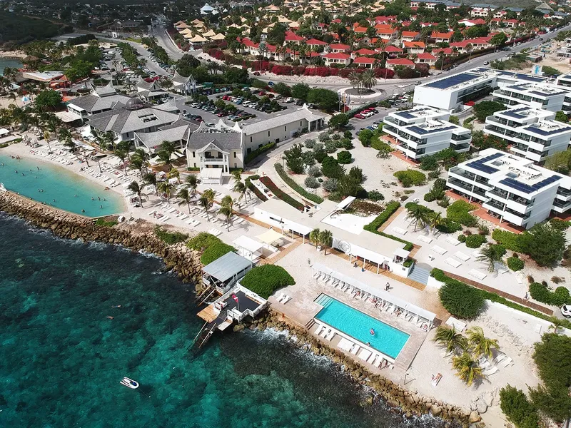 Vue aérienne d'un centre de plongée avec plage, piscine et bâtiments