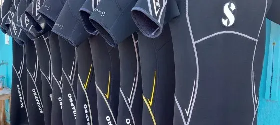 Rangée de combinaisons de plongée noires Scubapro suspendues pour le séchage