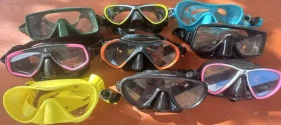 Masques de plongée de différentes couleurs et modèles sur fond orange