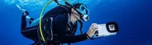 Plongeur équipé d'un appareil photo sous-marin en pleine exploration