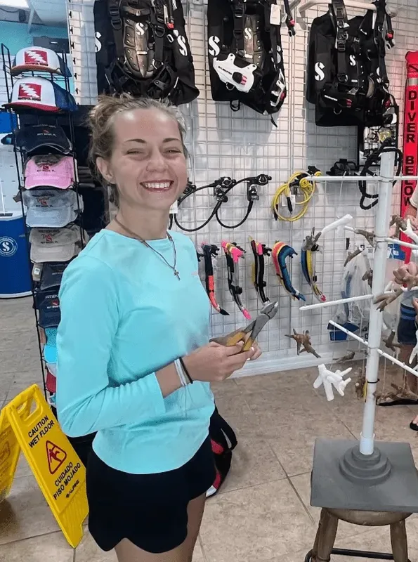 Jeune femme souriante dans un magasin de plongée bien équipé