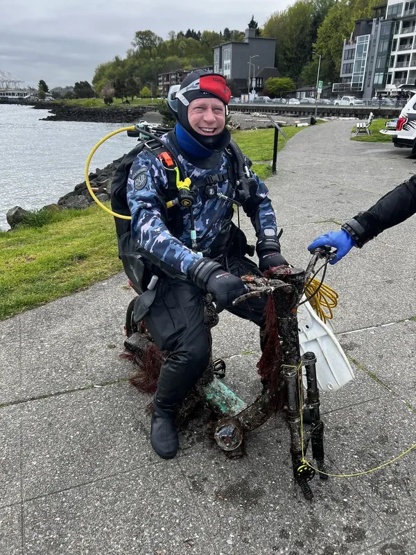 Plongeur souriant sur un quai avec palmes et équipement
