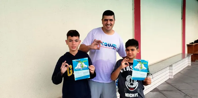Trois personnes souriantes présentent des cartes de certification PADI
