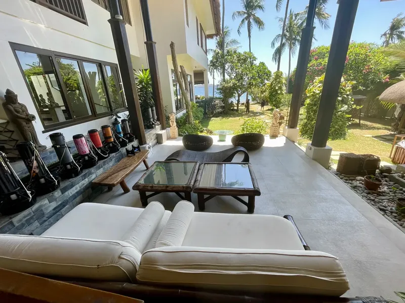 Terrasse ombragée avec mobilier, équipement de plongée et végétation tropicale
