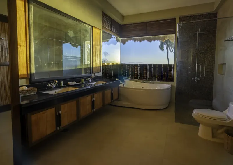 Salle de bain moderne avec baignoire, douche et vasque, vue sur mer
