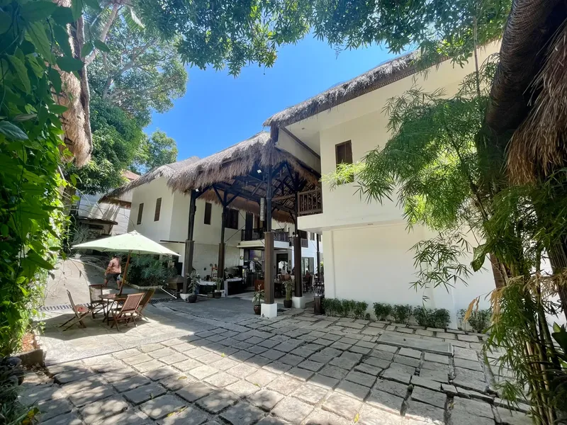 Cour intérieure d'un bâtiment blanc avec une personne assise à table